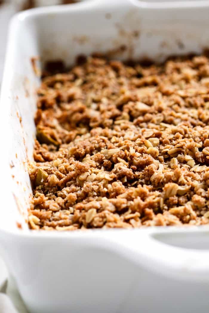 Apple crisp with almond butter topping in white baking pan