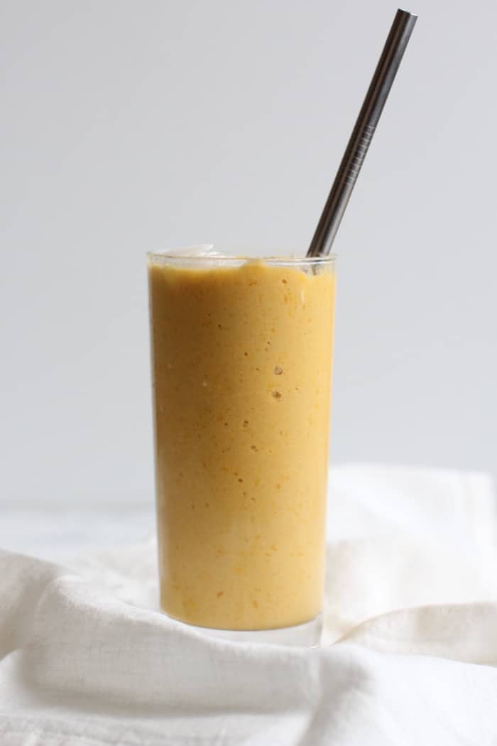Mango turmeric ginger smoothie in tall glass
