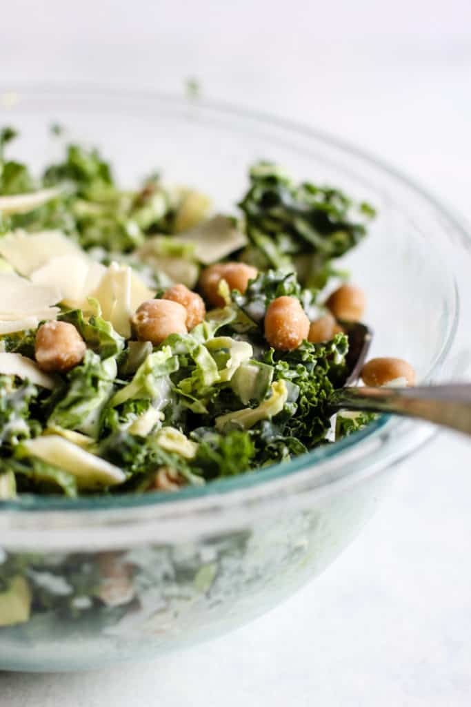Creamy kale Caesar with avocado salad in clear bowl