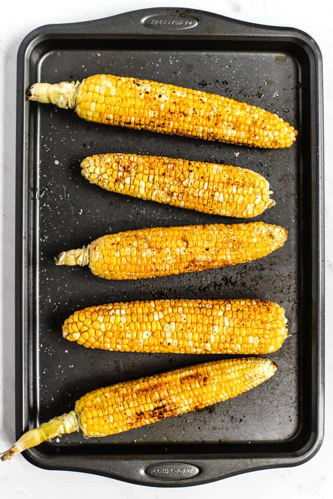 Five ears of roasted chipotle-spiced corn on the cob on sheet pan