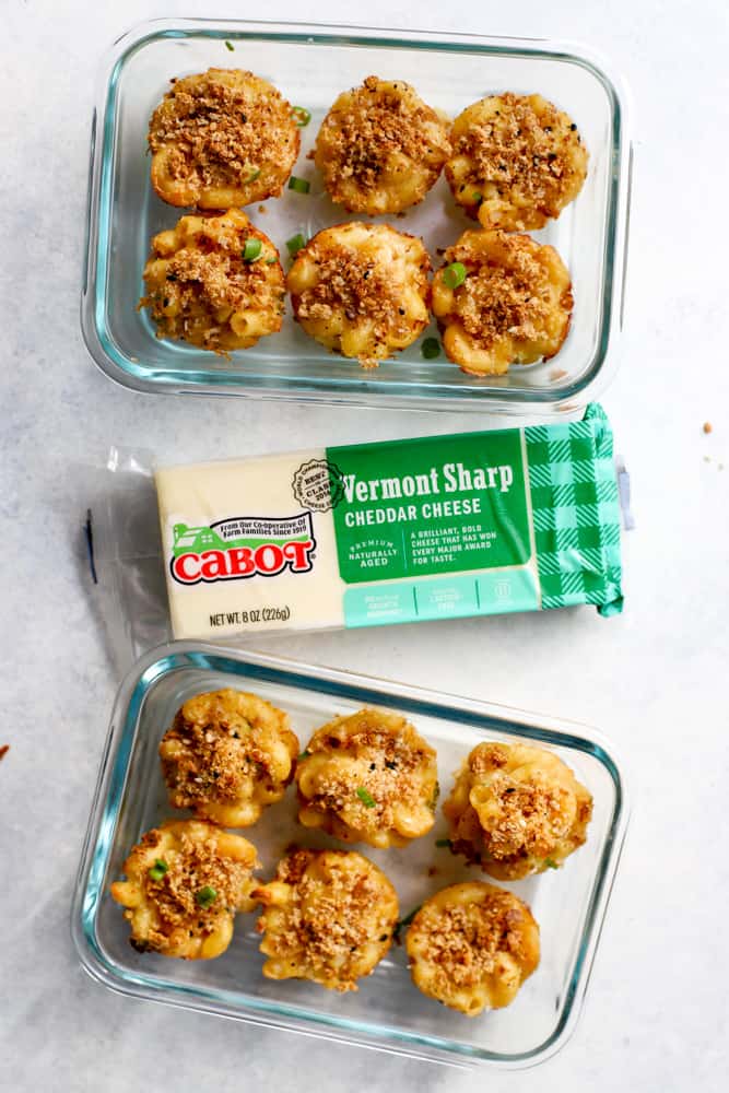 Healthy mac and cheese bites in meal prep containers next to Cabot Cheese block