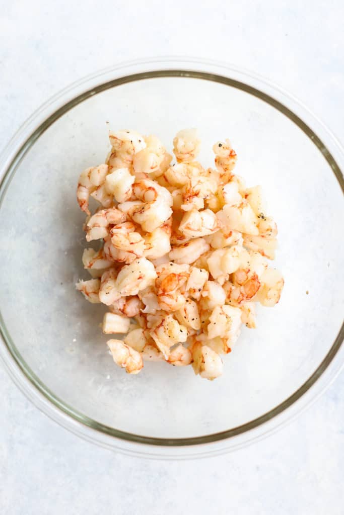 Cooked and chopped shrimp in clear glass bowl