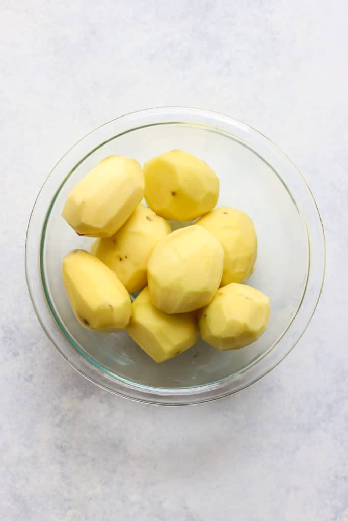 Peel Yukon gold potatoes in clear glass bowl