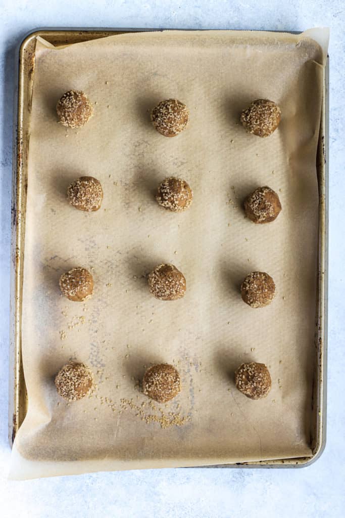 Ginger molasses cookie dough balls placed three inches apart on parchment-lined sheet pan