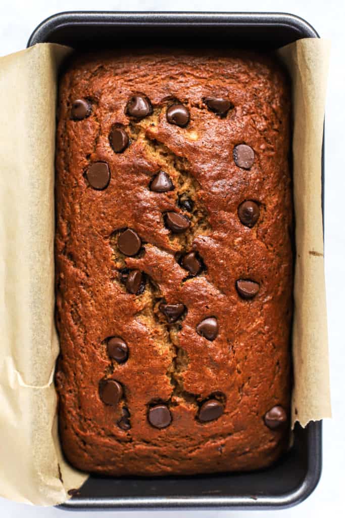 Spelt flour banana bread with chocolate chips in loaf pan lined with parchment paper