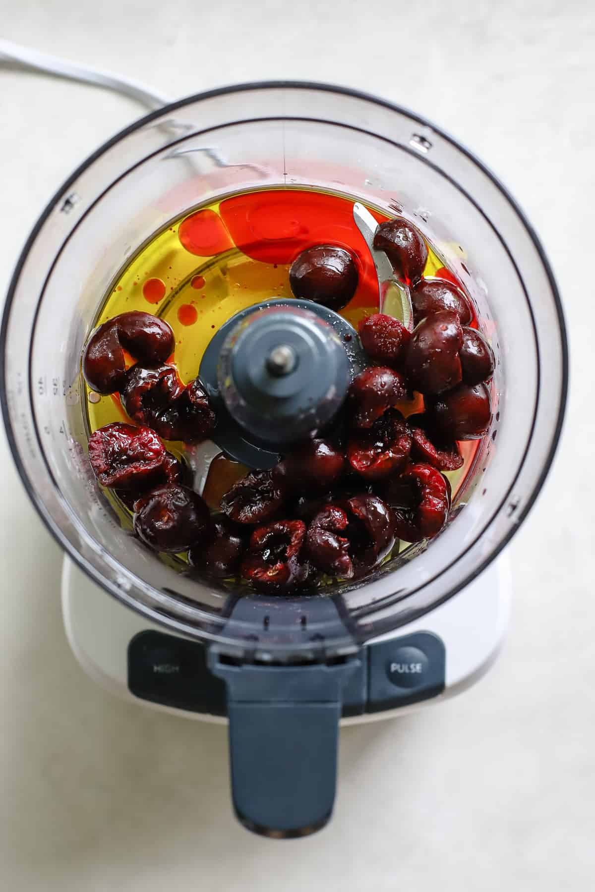 Cherries, olive oil, vinegar, and salt in food processor before being blended into vinaigrette